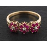 A 9ct gold ruby and diamond triple flowerhead ring, estimated total ruby weight ca. 0.