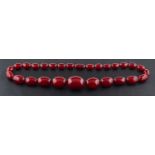 A graduated red amber bead necklace, length of beads ca. 1.3-2.8cm, total length ca.