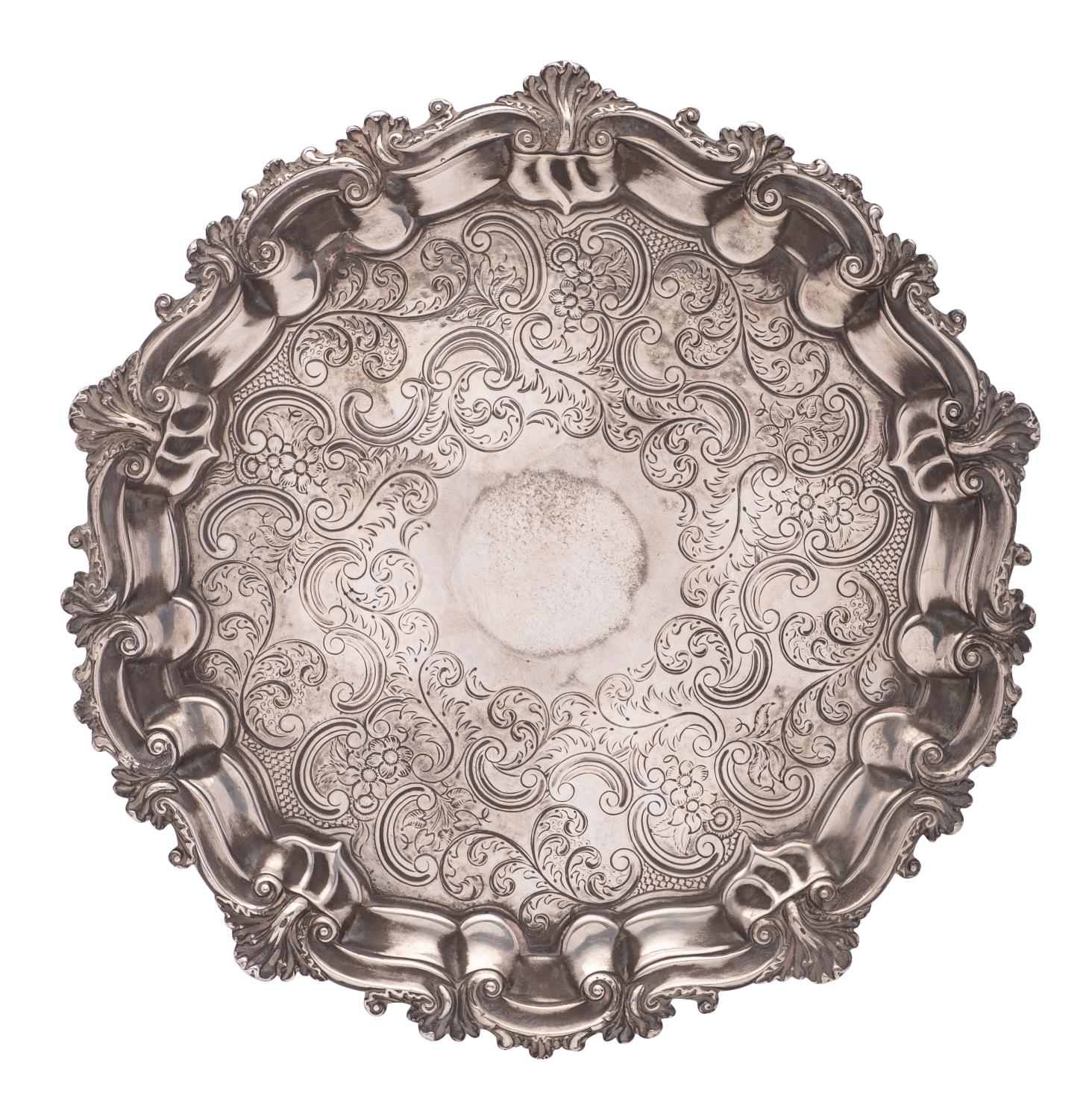 A Sheffield Plate salver, with engraved foliate and scroll decoration, raised on three swept feet,