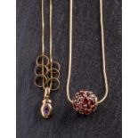 Two gemset pendants, including a spherical garnet set pendant, stamped '14K', diameter ca. 1.