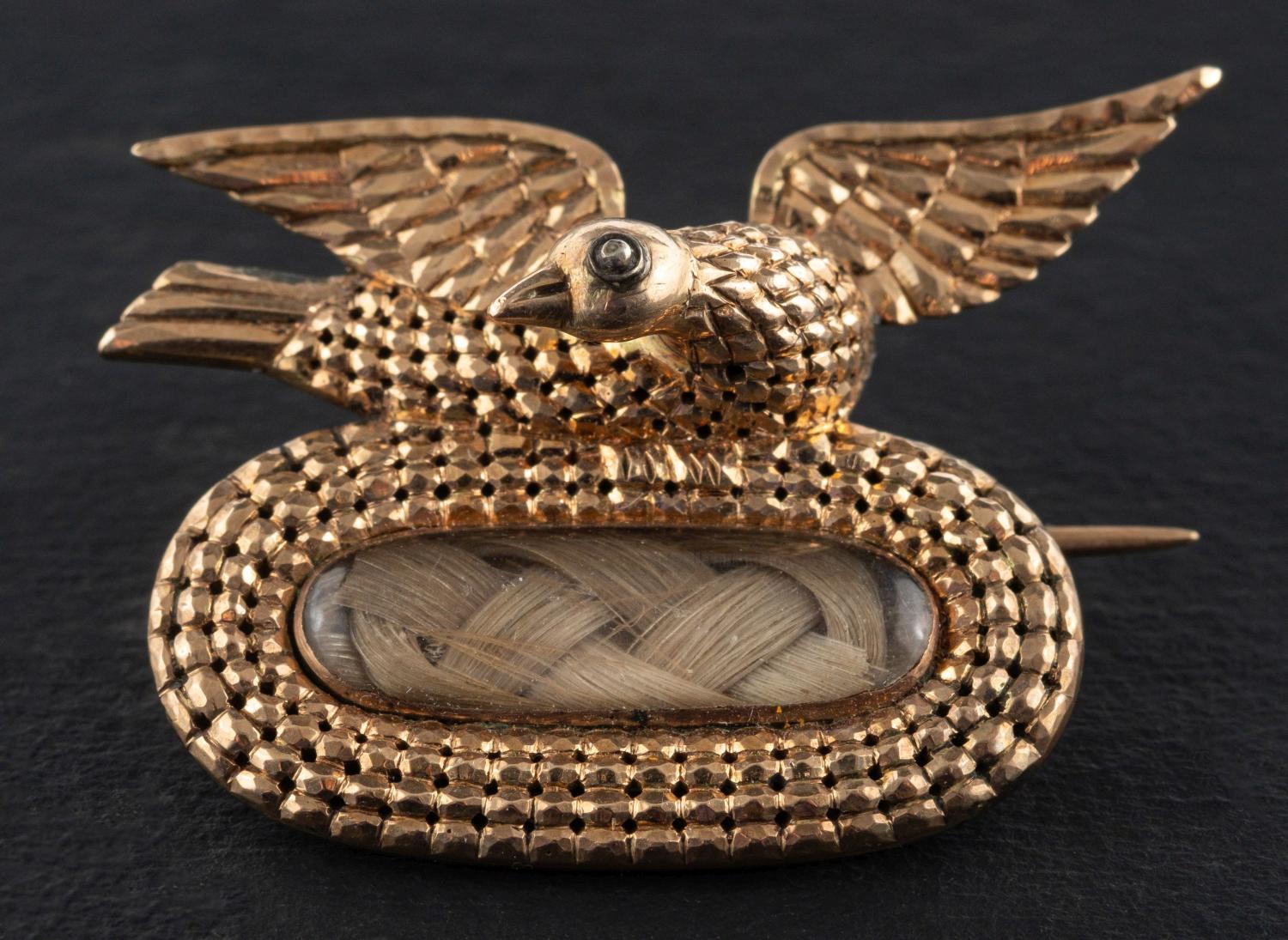 A Georgian memorial brooch with hairwork, surmounted by a dove,