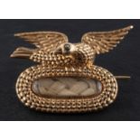 A Georgian memorial brooch with hairwork, surmounted by a dove,