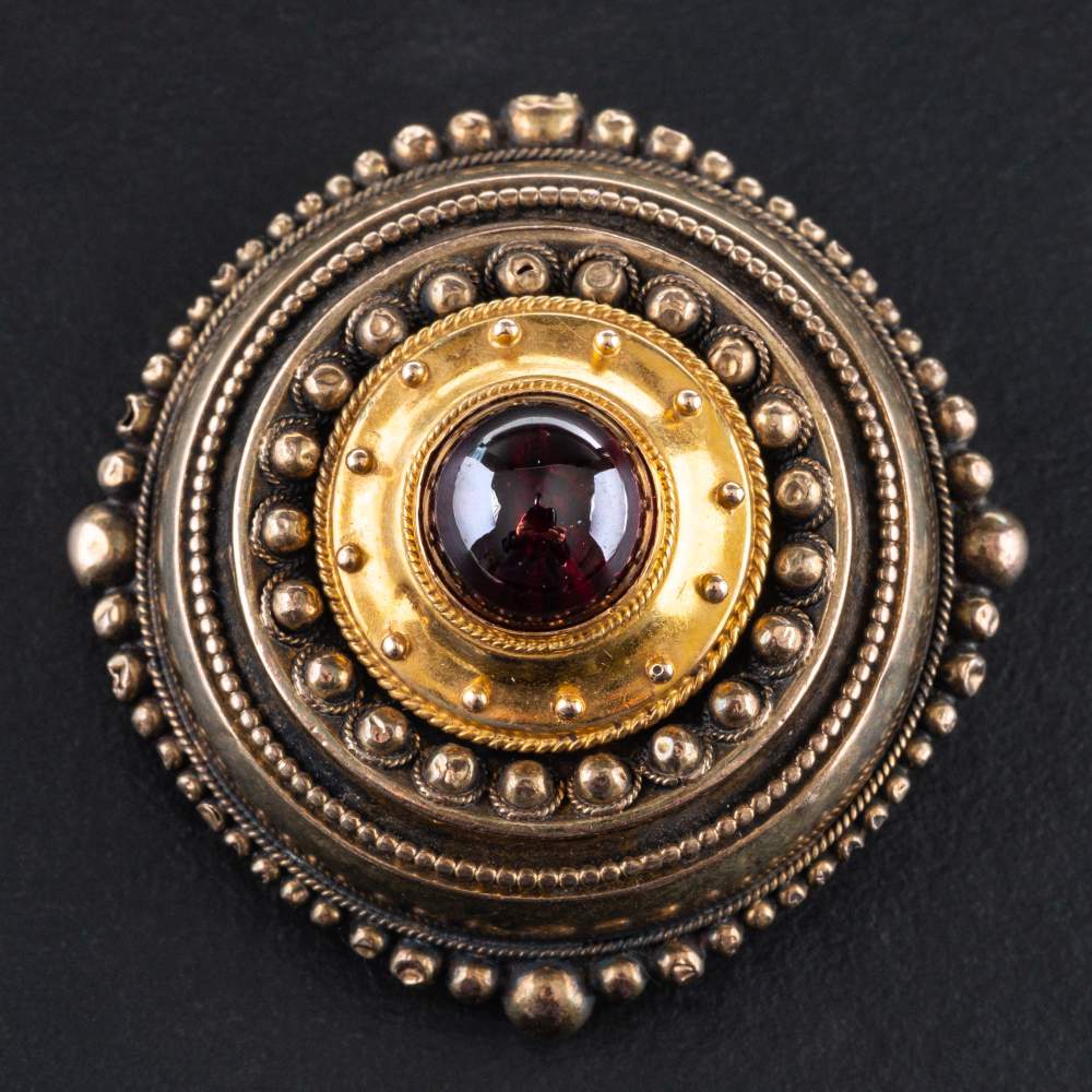 A 15ct gold, late Victorian, Etruscan Revival style, cabochon-cut garnet brooch, diameter ca. 3.