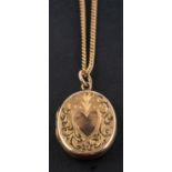 An oval locket pendant, with engraved with heart-shaped and foliate decoration, stamped '9CT',