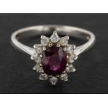 An 18ct gold, oval, mixed-cut ruby and round, brilliant-cut diamond cluster ring,