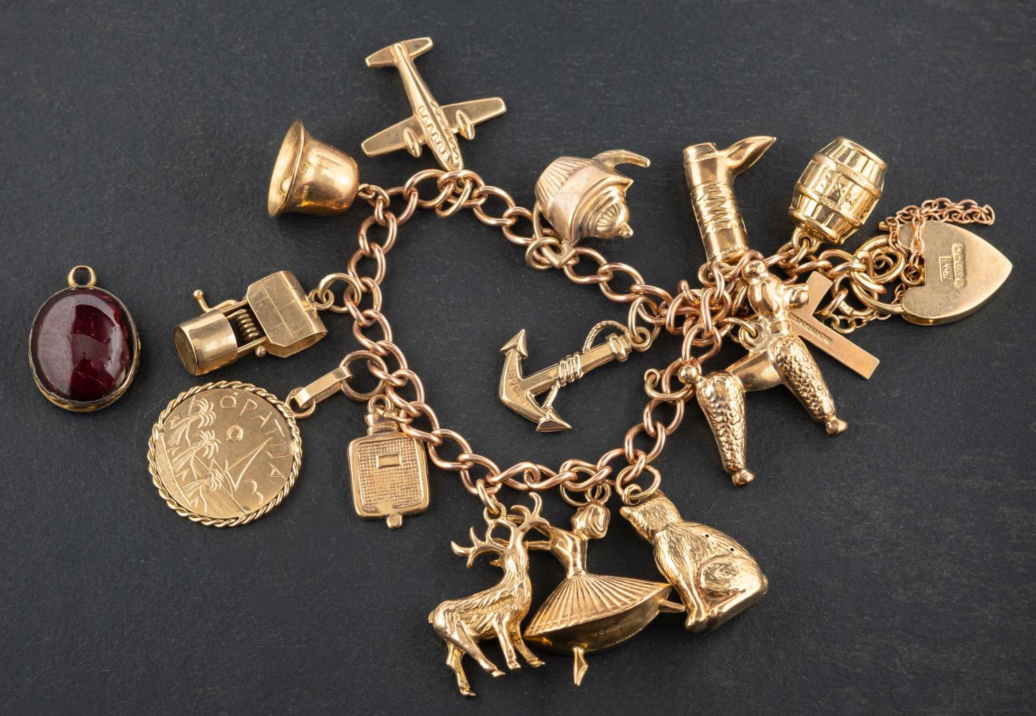 A 9ct gold, curb-link charm bracelet with heart-shaped clasp, with hallmarks for 1987,