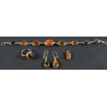 A pressed amber, spectacle set bracelet and pair of earrings,