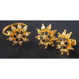 A pair of sapphire and white paste ear studs and ring, of stylised flowerhead design,