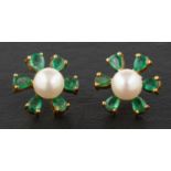 A pair of cultured pearl and pear-shaped emerald ear studs, of flowerhead design,