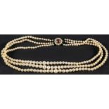 A three-row, graduated, cultured pearl necklace, the pearls of yellowish hue with pink overtones,