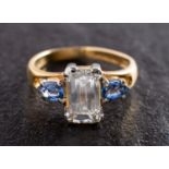 An 18ct gold, octagonal, step-cut diamond and pear-shaped sapphire three-stone ring,