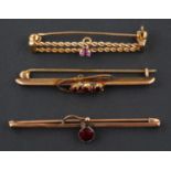 Three bar brooches, including a 9ct gold amethyst brooch; a three-stone garnet brooch,