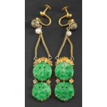 A pair of drop earrings set with cultured pearls and two carved jadeite, pierced, circular plaques,