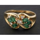 A round, brilliant and marquise-cut diamond and emerald ring, of floral design,