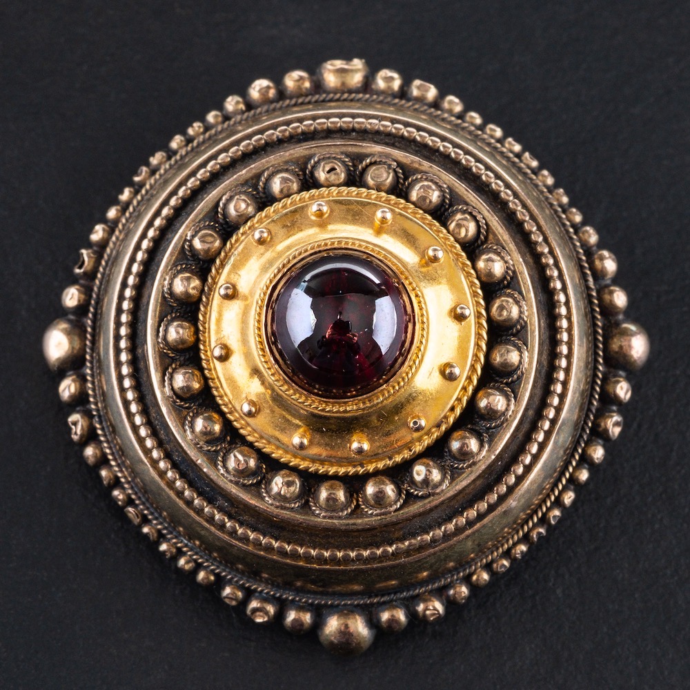 A 15ct gold, late Victorian, Etruscan Revival style, cabochon-cut garnet brooch, diameter ca. 3. - Image 2 of 2