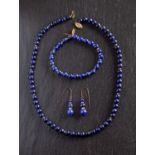 A lapis lazuli bead necklace, bracelet and pair of drop earrings,