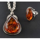 A pear-shaped amber pendant and ring, with applied foliate decoration,