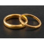 Two 22ct gold band rings, including one with engraved floral decoration,