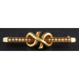 A Victorian seed pearl bar brooch with knot decoration, stamped '15C', length ca. 4.