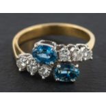 An 18ct gold, oval, mixed-cut probably synthetic sapphire and round,