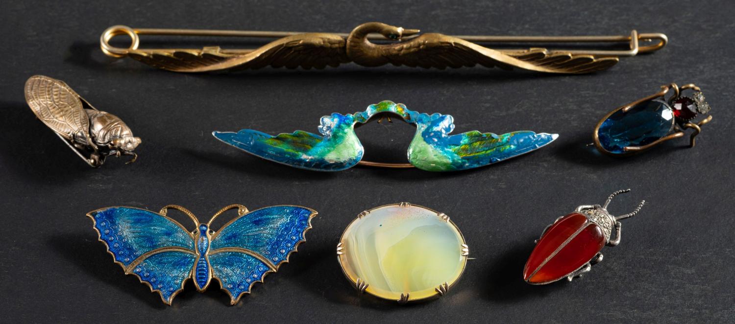 A collection of seven brooches, including, amongst others, a moth brooch,