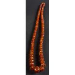 A graduated, faceted amber bead necklace, diameter of beads ca. 8-25mms, total length ca.