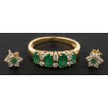 A marquise-shaped emerald, three-stone ring with round, brilliant-cut diamond spacers,