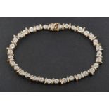 A 9ct bi-colour gold single-cut diamond line bracelet, according to engraving diamond weight 0.