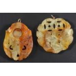 Two carved bowenite serpentine pendants, one depicting a pair of doves, the other of foliate motif,