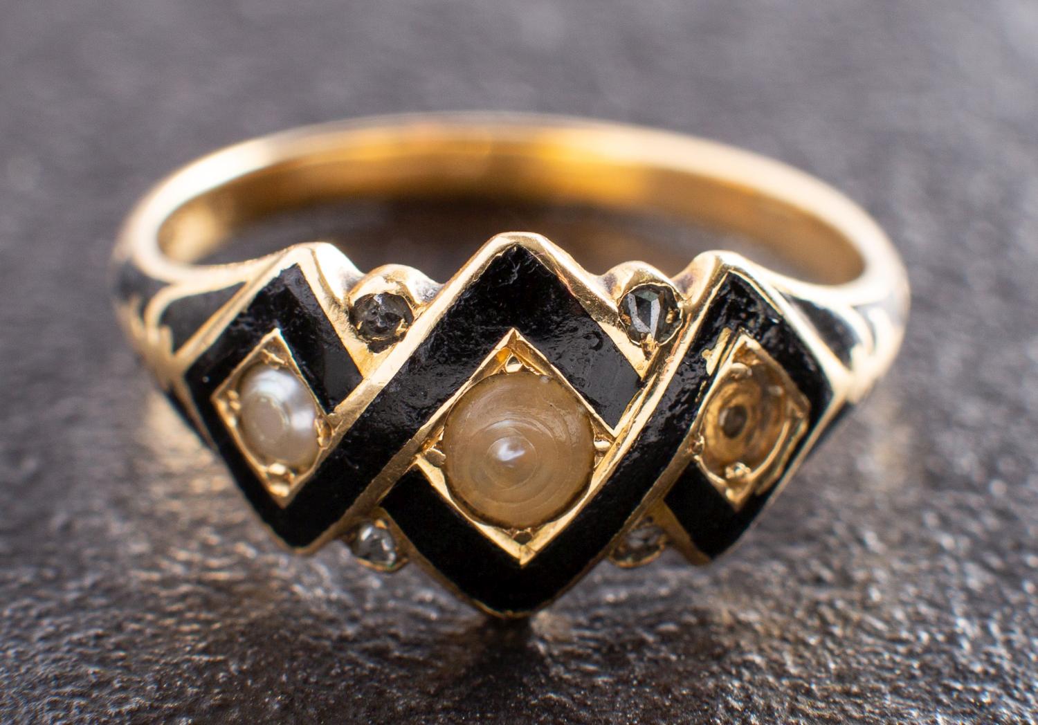 A 19th century seed pearl and black enamel mourning ring,