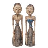 A pair of Indonesian polychrome carved wood male and female figures in traditional plain costume,