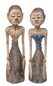 A pair of Indonesian polychrome carved wood male and female figures in traditional plain costume,