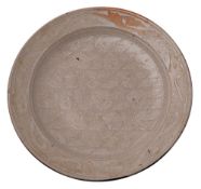 A stoneware charger by an unknown hand the upper surface with ivory wax resist decoration the