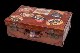 A 1930's style leather suitcase of rectangular outline with reproduction hotel labels, 57cm wide.