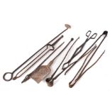 A collection of wrought iron fire implements, including tongs, pokers, rake and shovel.