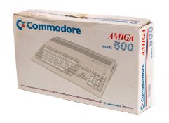 A Commodore Amiga Model 500 Personal Home Computer with mouse and floppy disk drive,