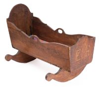 An early 20th century Danish oak crib, carved and dated '13 Oktober 1902', raised on sleigh rockers,