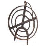 A circular wrought iron revolving grid iron with scrollwork designs and tripod feet, 31cm diameter,