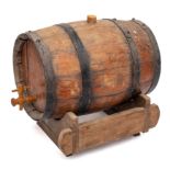 A coopered barrel with tap, on a wood stand, 32cm long.