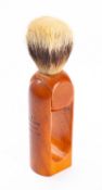 A Louis Vuitton travel shaving brush, the badger hair brush on a rotating resin handle.