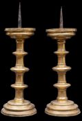 A near pair of late 16th century German brass pricket candlesticks with circular wax pans,