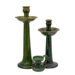 Two green glazed earthenware tall candlesticks and a similar jug,