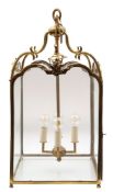 A gilt metal and glazed hall lantern of square outline with double arches panels on swept and