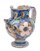 An Italian maiolica wet drug jar painted with a portrait cartouche on a blue ground of flowers and