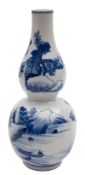 A Chinese blue and white double gourd vase painted with mountainous lake landscapes with buildings