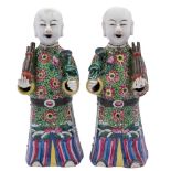 A pair of Chinese porcelain figures, each wearing elaborate famille rose decorated robes,