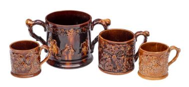 A large 19th century treacle-glazed frog loving-cup, three similar and seven other frog mugs,