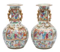 A pair of Canton baluster vases with shaped turnover rims and gilt lion dog and puppy handles,
