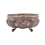 An Burmese silver circular bowl with beaded rim and raised ovule-shaped panels decorated with