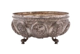 An Burmese silver circular bowl with beaded rim and raised ovule-shaped panels decorated with